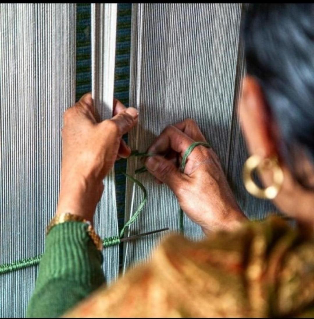 Skilled master artisans weaving luxury handmade carpets on a traditional loom in Bhadohi India
